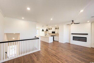 Unfurnished living room with dark wood-style floors, recessed lighting, a fireplace, crown molding, and ceiling fan