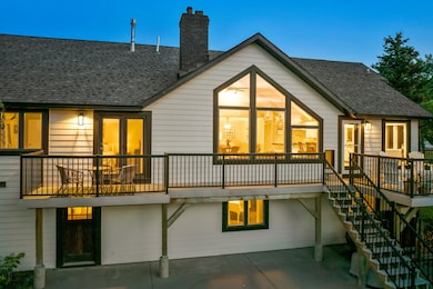 Rear view of house featuring a chimney, roof with shingles, stairs, and a patio