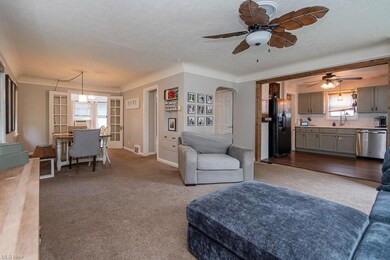 Living room featuring a textured ceiling, light carpet, and ceiling fan