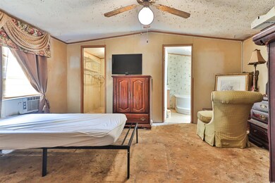 Bedroom featuring ceiling fan, cooling unit, ensui