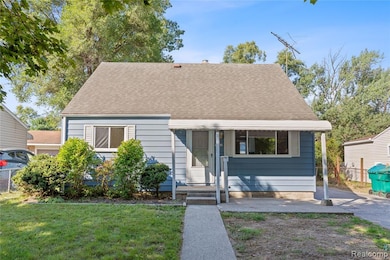 View of front of home featuring a shingled roof and a front yard