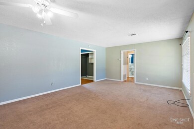 Empty room featuring light carpet, ceiling fan, an