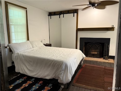 Bedroom with wood finished floors and a fireplace