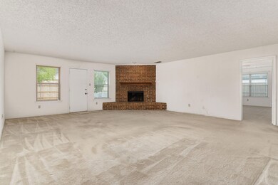Unfurnished living room featuring a textured ceili