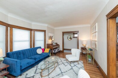Living room with built-in leaded glass cabinets, bay window & hardwood floors