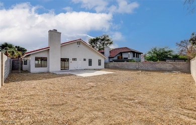Back of house with a patio area, a chimney, a fenced backyard, and stucco siding
