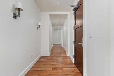 Hallway featuring light wood-style floors and bas