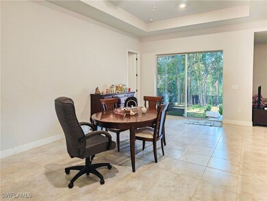 Dining room with a tray ceiling and light tile pat