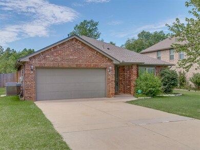 View of front of property featuring central air condition unit, a front yard, and a garage
