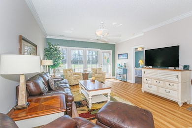 Living room with ceiling fan, ornamental molding, 