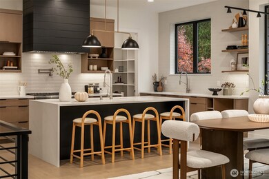 Step into a culinary dream with Thermador appliances, a 48-inch six-burner range, oak cabinets, walk-in pantry, and a quartz double-waterfall island that anchors the space.