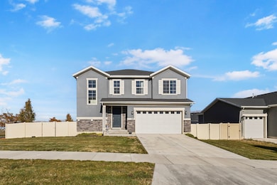 View of front of home featuring stucco siding, a garage, concrete driveway, and stone siding