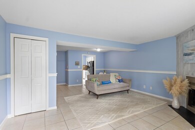 Living area featuring light tile patterned floors and baseboards