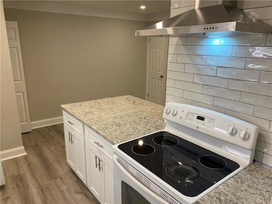 Kitchen featuring white electric stove, white cabi