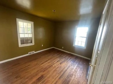 Unfurnished room featuring dark wood-style floors and healthy amount of natural light