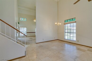 Spare room featuring a high ceiling, a ceiling fan