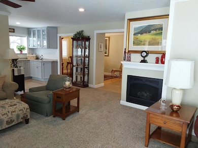 The living room offers 3 distinct spaces for sitting, watching TV, or game table.
