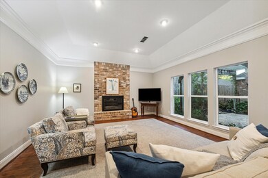 Floor to ceiling brick fireplace has gas logs and