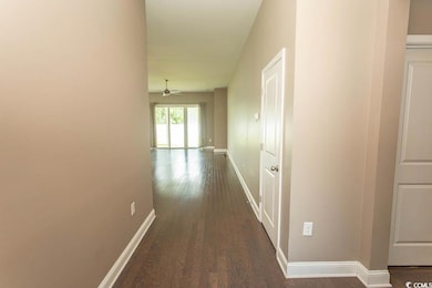 Hallway featuring dark wood finished floors and baseboards