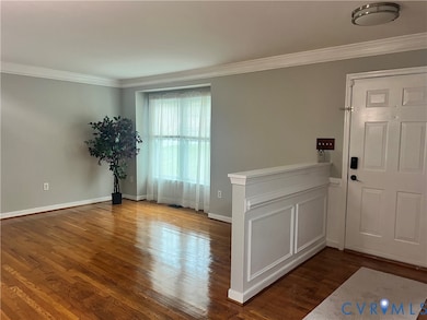 Foyer featuring ornamental molding and dark wood-style floors