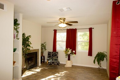 Sitting room with ceiling fan, visible vents, woo
