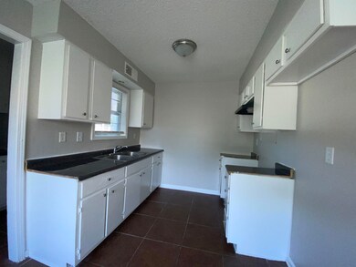 Kitchen featuring sink, white cabinetry, a texture