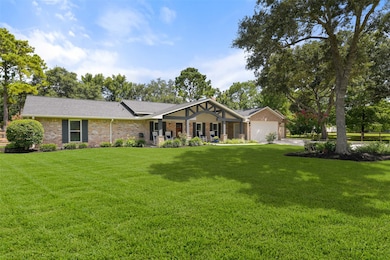An extra-long paved driveway leads from Falling Leaf Drive amidst the towering trees that dot this property to this charming single-story home with ample parking space and a brick elevation with wood shutters and the most inviting gabled front porch.