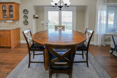 Dining room with dark wood-style flooring and a chandelier