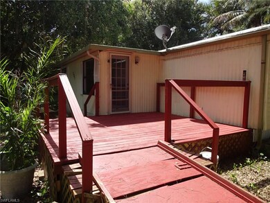WOOD DECK IN FRONT OF THE HOUSE NEAR FRONT ENTRY.    A RAMP WAS ADDED SEVERAL YEARS AGO, BUT THERE ARE STILL WOOD STEPS ON THE OTHER SIDE OF THIS DECK.   WONDERFUL PLACE TO SIT OUT AND GET SOME SUNSHINE.