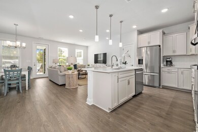 Kitchen with a sink, decorative backsplash, stainless steel appliances, and dark wood-style flooring