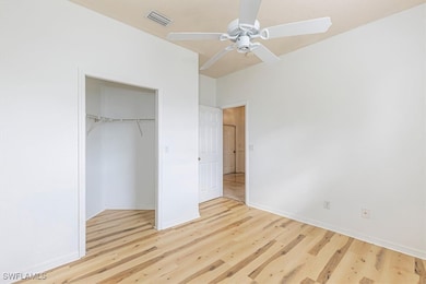 Unfurnished bedroom with light wood-style floors, ceiling fan, and a closet