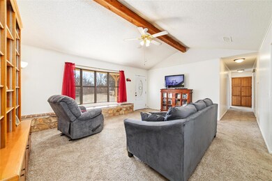 Carpeted living room featuring lofted ceiling with