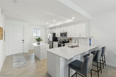 Kitchen with a kitchen breakfast bar, a center island, appliances with stainless steel finishes, a peninsula, and white cabinetry