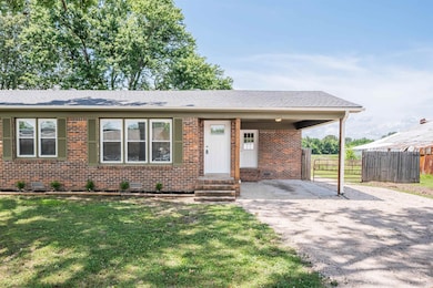 View of front facade featuring asphalt driveway, brick siding, entry steps, crawl space, and a shingled roof