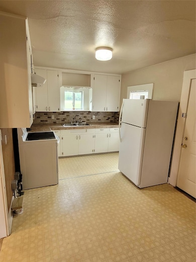 Kitchen featuring freestanding refrigerator, stov