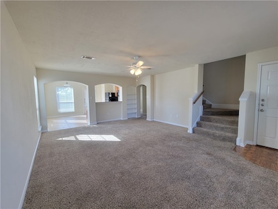 Unfurnished living room with carpet, ceiling fan,