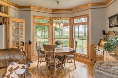 The dining area features a bay window, a restored antique light fixture, and vintage French doors leading to the kitchen.