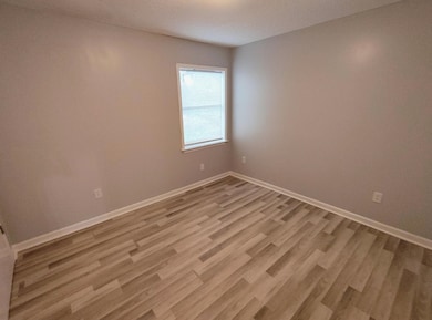 Spare room featuring light wood-style floors and a textured ceiling