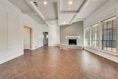 Unfurnished living room with beamed ceiling, a brick fireplace, a decorative wall, and recessed lighting
