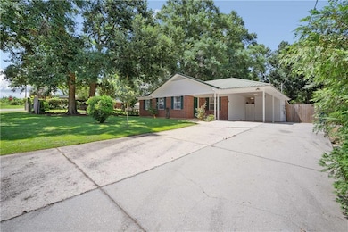 Ranch-style house featuring concrete driveway, a carport, and brick siding