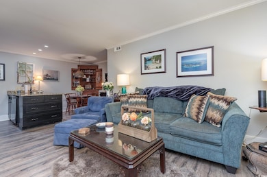 Living room with ornamental molding and light wood