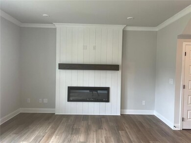 Unfurnished living room featuring a fireplace, ornamental molding, and dark wood-style flooring