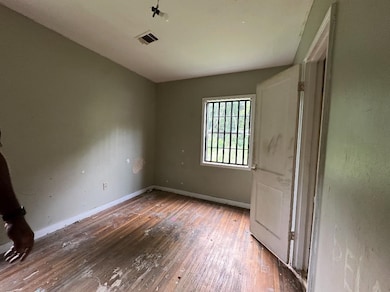 Unfurnished bedroom with hardwood / wood-style flooring and baseboards