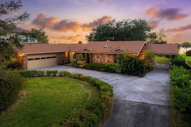 View of front facade featuring concrete driveway, a chimney, a lawn, and a garage