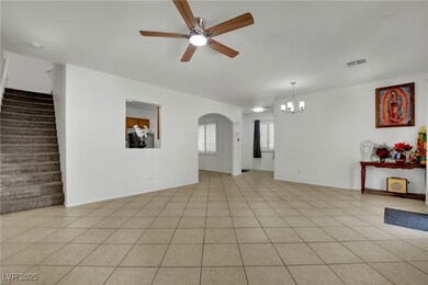 Empty room featuring ceiling fan, a chandelier, st