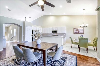 Dining space with arched walkways, ceiling fan, li