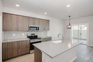 Kitchen featuring stainless steel appliances, light wood finished floors, decorative backsplash, and recessed lighting