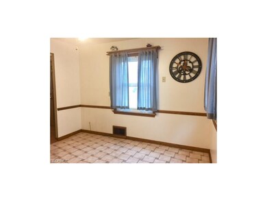 Kitchen eating area has plenty of room for a large table & a potable center island.  Easy care ceramic tile floor, newer vinyl windows, ceiling fan/light and chair rail all add a nice touch to this lovely kitchen!