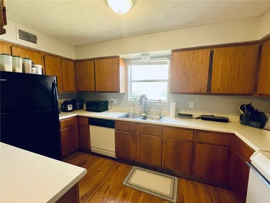 Kitchen with visible vents, black appliances, ligh
