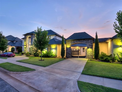 View of front of house with driveway, stone siding, a lawn, a gate, and stucco siding